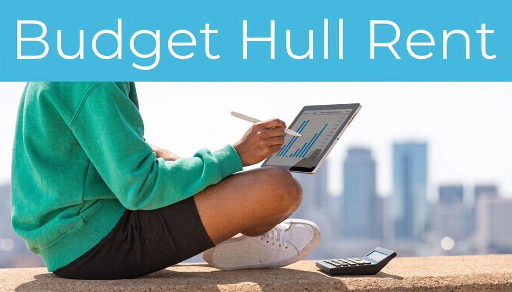 A person in a green sweater sits outdoors holding a tablet displaying financial graphs with a calculator.