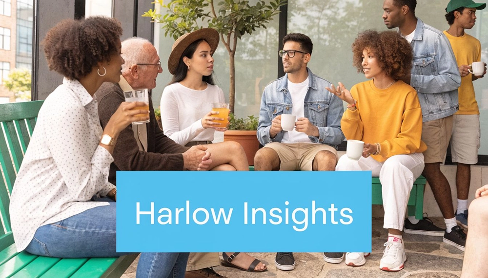 A diverse group of young adults and an older man socialising outdoors with drinks and conversation.